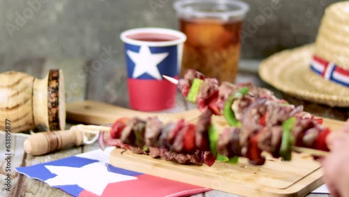 Fiestas Patrias Chile September 18, Independence Day. Empanadas, Anticuchos, mote con huesillo, chicha or wine, Sombrero, huaso, chupallas, straw and emboque, on wooden table with flag and copy space photo