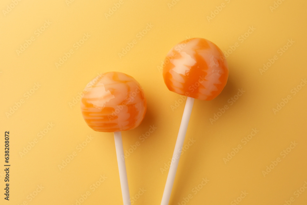 Tasty lollipops on orange background, flat lay Tasty lollipops on orange background, flat lay