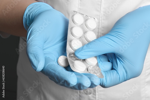 Doctor taking pill out from blister pack, closeup