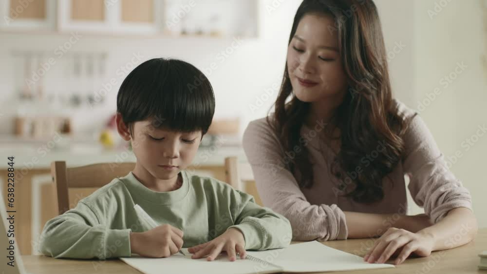 young asian mother helping son with homework at home young asian mother helping son with homework at home