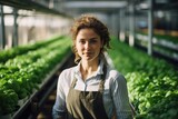 Smiling portrait of a young caucasian woman working in an organic farm greenhouse