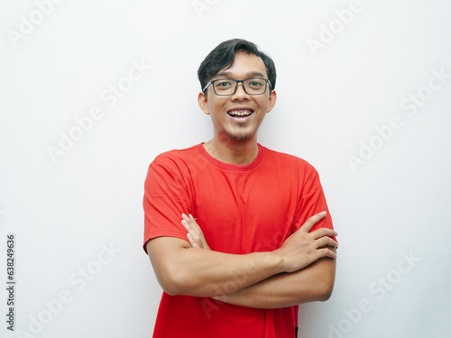 Portrait Indonesian Asian young man smiling and crossing hands in front of her chest. Red t-shirt for August 17 Indonesia independence day concept