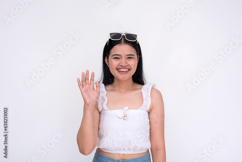 A young asian woman saying hello. A warm greeting from a friend. Isolated on a white background. © Mdv Edwards