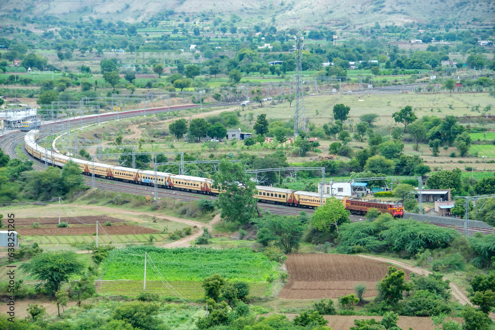 WCAM2P Electric Locomotive hauls a passenger train at Shindawane near Pune India.