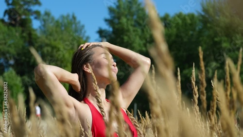 Portrait of a beautiful asian woman on the background of dry long grass while relaxing in summer. slow motion portrait. photo