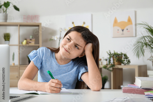 Upset little girl doing lessons at home