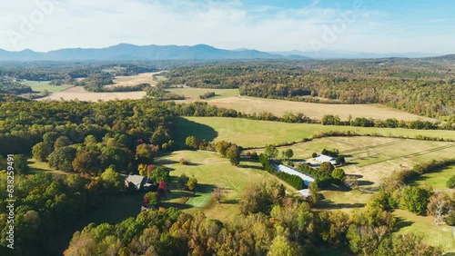 View from above of rural America in North Carolina. Big expensive residential house surrounded with farm fields and dense forest close to Appalachian mountains photo
