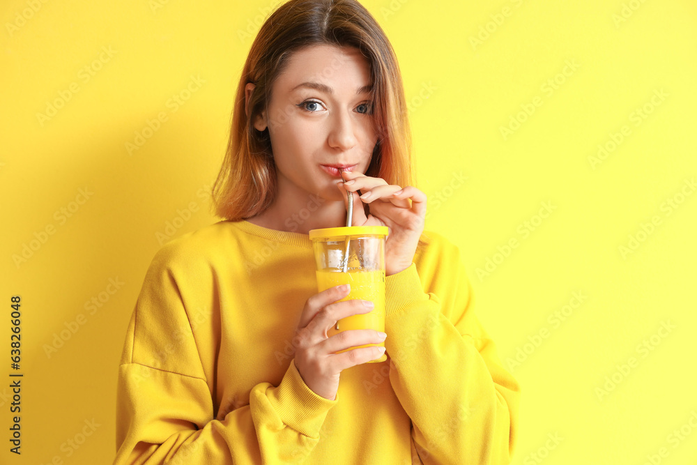 Young woman drinking juice on yellow background Young woman drinking juice on yellow background
