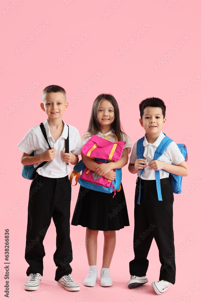 Little school children with backpacks on pink background Little school children with backpacks on pink background