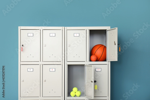 Obraz na plátně Modern locker with sports equipment near blue wall