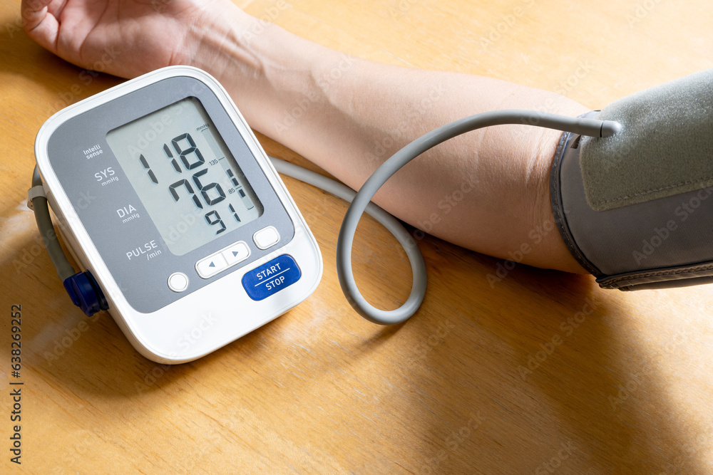 Man check blood pressure monitor and heart rate monitor with digital pressure gauge. Health care and Medical concept Man check blood pressure monitor and heart rate monitor with digital pressure gauge. Health care and Medical concept