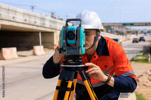 engineer use theodolite equipment  for route surveying to build a bridge across the intersection to reduce traffic congestion during rush hours photo