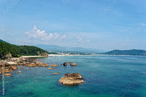 a landscape with a blue sea and clouds