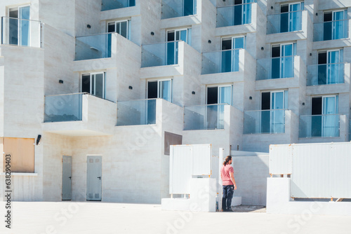 Fototapeta Naklejka Na Ścianę i Meble -  Un homme devant la construction de nouveaux immeubles à Majorque. Construction de résidences à Majorque. Immeubles en construction aux Baléares.
Port de Pollença
