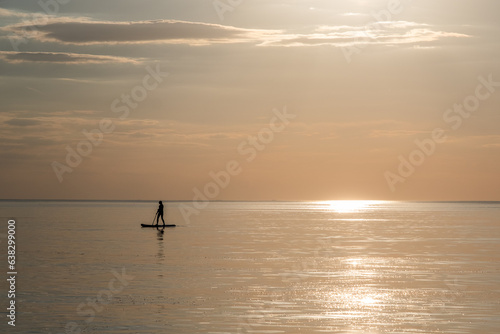 sunset on the sea with surfer