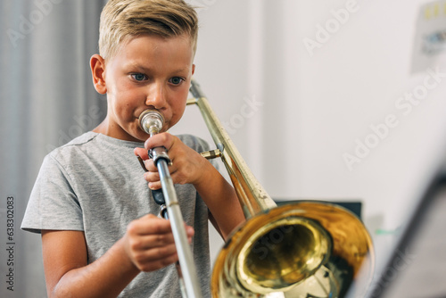 Young boy practicing trombone alone. photo