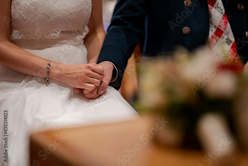 Married couple hold their hands during the wedding ceremony