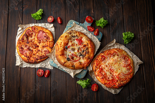Three mini pizzas on brown boards. Bakery products. Fresh bakery.