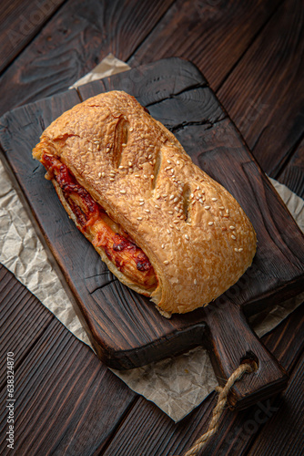 Lush puff with meat, vechina, mushrooms, potatoes on brown boards. For decoration of bakery sales outlets. Bakery products. Fresh bakery.