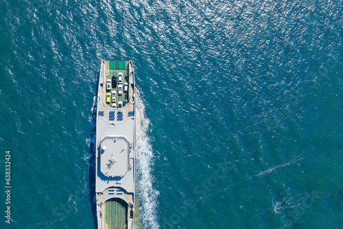 Ferry carrying cars and passengers across the sea, top down aerial drone view. Ferry transporting cars. Aerial view photo