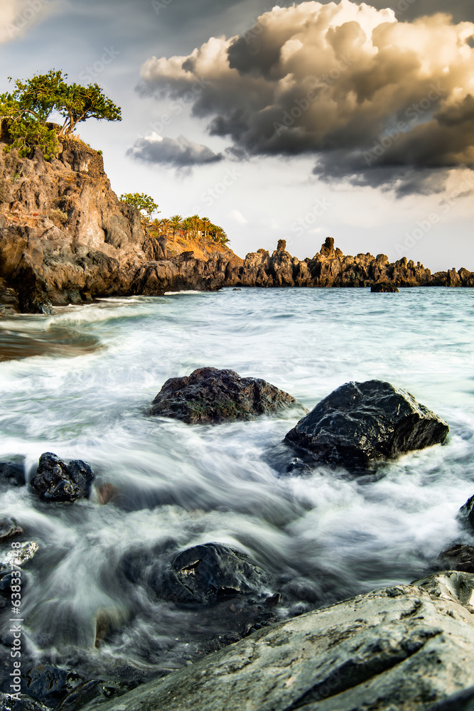 Fototapeta premium Exclusive beach of Tenerife. Beautiful sunset by the Atlantic Ocean. Epic volcanic rocks, cliffs, black sand, waves, turquoise water. Premium landscape from pure nature, town Alcalá, Canary Islands 