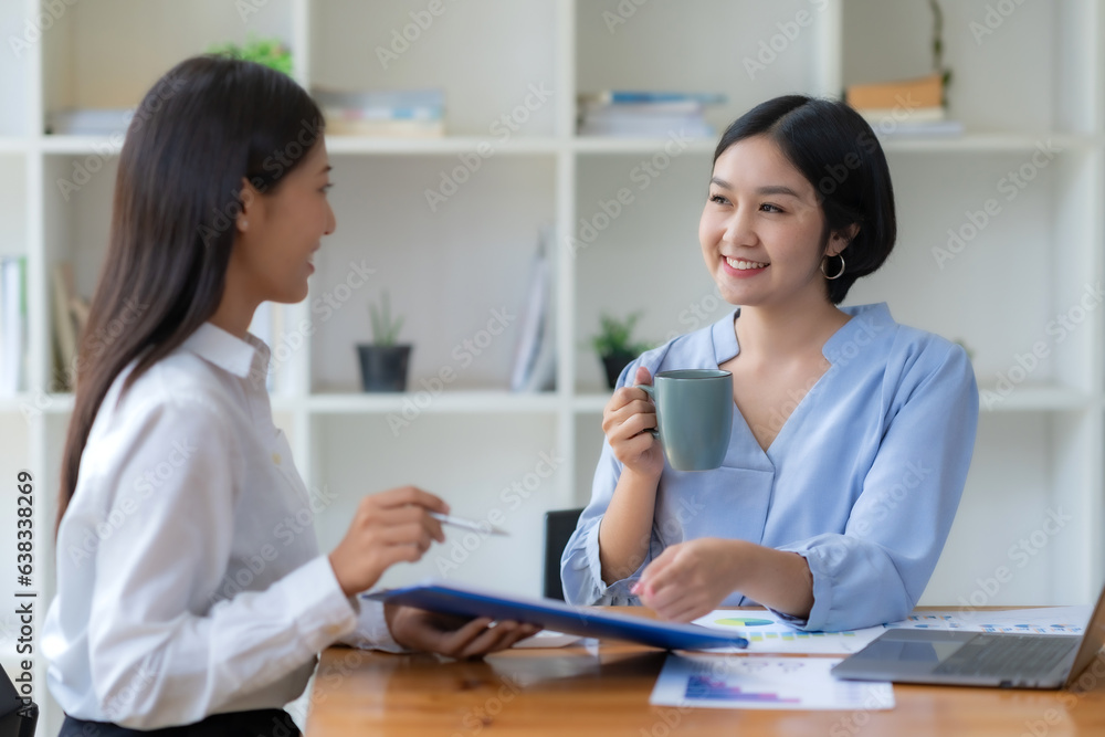 Two happy asian businesswoman talking and consulting working together in the office Two happy asian businesswoman talking and consulting working together in the office