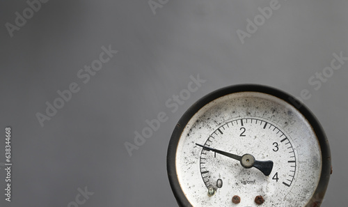 An old gauge for air pressure in front of a blurred, grey background. photo