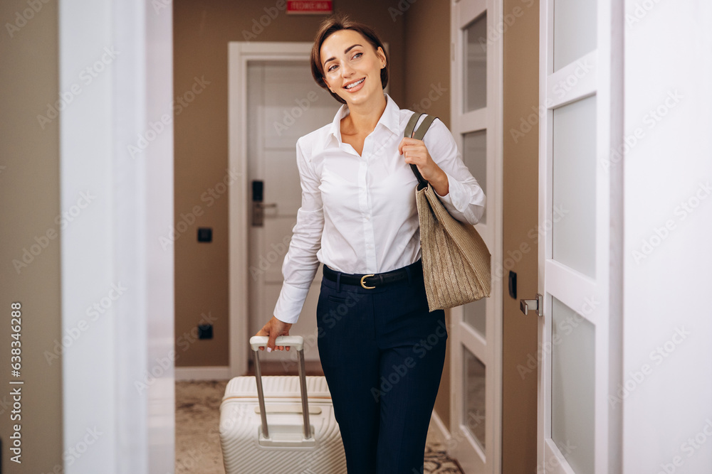 Business woman walking into hotel room with luggage Business woman walking into hotel room with luggage