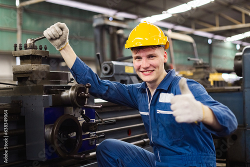 Happy male workers wear yellow hard hat holding wrench working on repairing factory machinery. man maintenance Factory, mechanical repairman concept. © eakgrungenerd