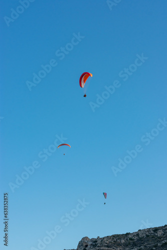 group of paragliders flying on a sunny day