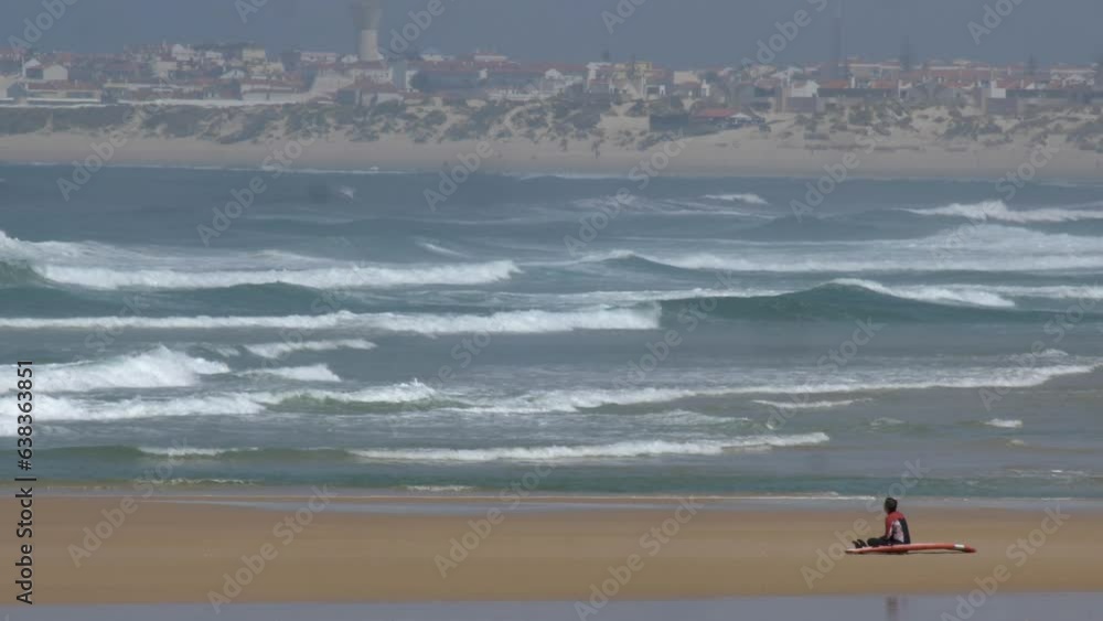 Anonymous Surfer Sitting on Atlantic Ocean Coast Sandy Beach in Portugal Anonymous Surfer Sitting on Atlantic Ocean Coast Sandy Beach in Portugal