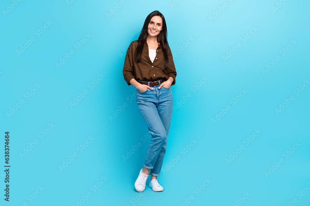 Full body photo of young business woman hands pockets denim jeans posing model vogue levis brand clothes isolated on blue color background Full body photo of young business woman hands pockets denim jeans posing model vogue levis brand clothes isolated on blue color background