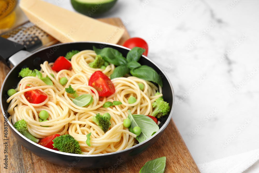 Delicious pasta primavera in frying pan and ingredients on white table, closeup