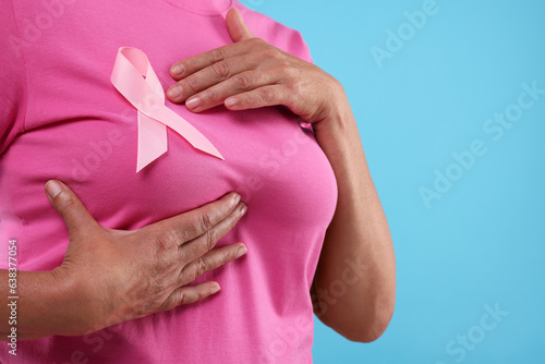 Wallpaper Mural Woman with pink ribbon on light blue background, closeup and space for text. Breast cancer awareness Torontodigital.ca