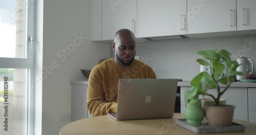 Man using laptop while working in kitchen