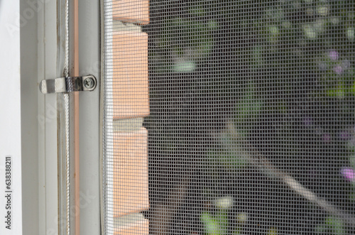 Mosquito screen. Close up on house mosquito wire screen with metal holders on window to protect from insects.