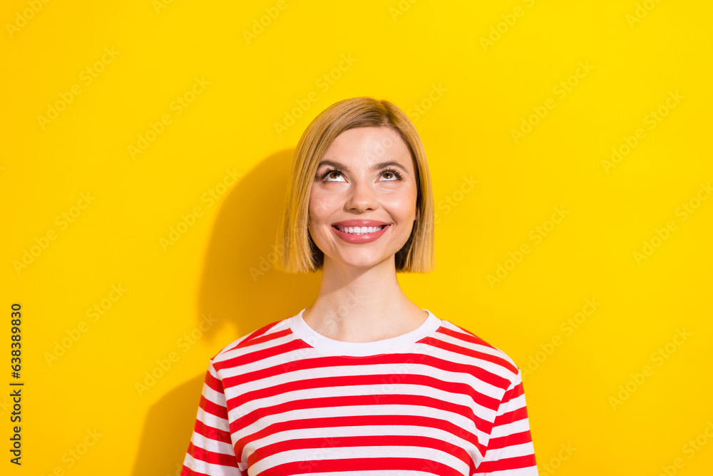 Photo of positive glad girl toothy smile wear fashionable clothes look up promo poster empty space isolated on yellow color background Photo of positive glad girl toothy smile wear fashionable clothes look up promo poster empty space isolated on yellow color background