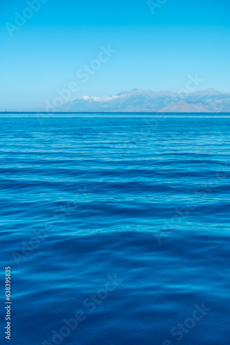 Turquoise sea water texture with sun rays in the mediterranean sea and sky background
