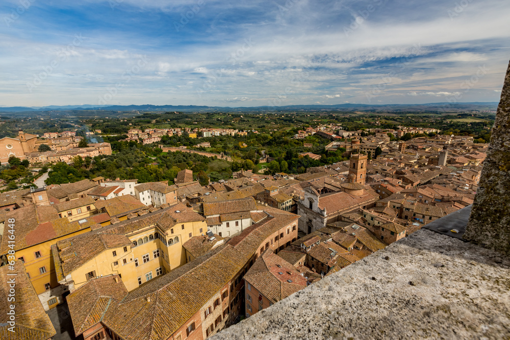 Siena, Tuscany, Italy, tiled roofs, view from the historic city tower, blue sky background with beautiful clouds