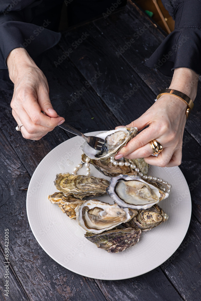 large, beautiful, fresh oysters on a dark table. Close up