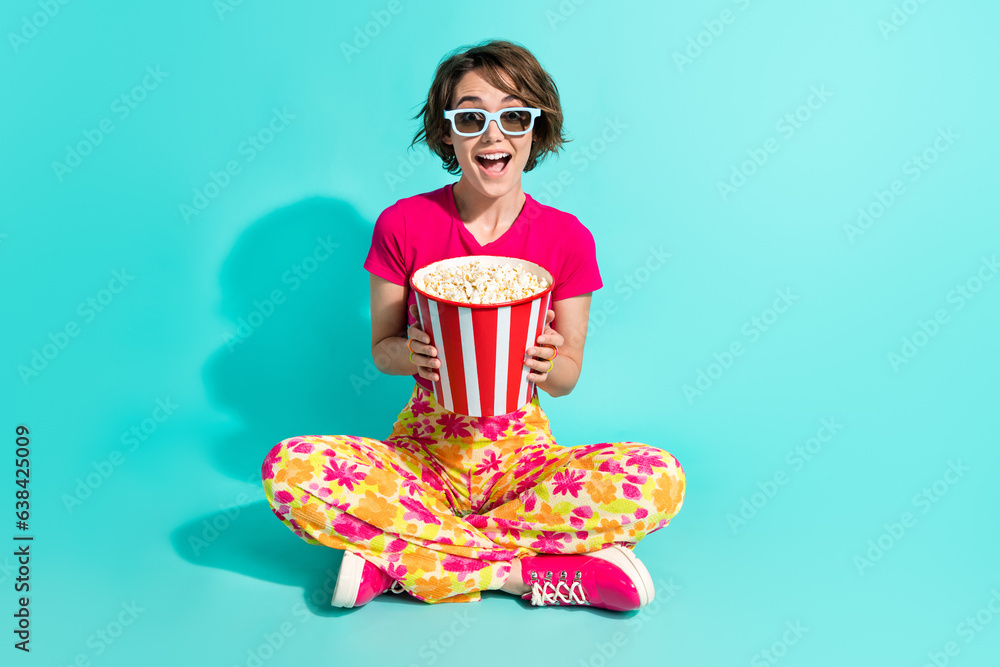 Full length photo of pretty impressed lady flower print pants watching movie eating pop corn isolated turquoise color background