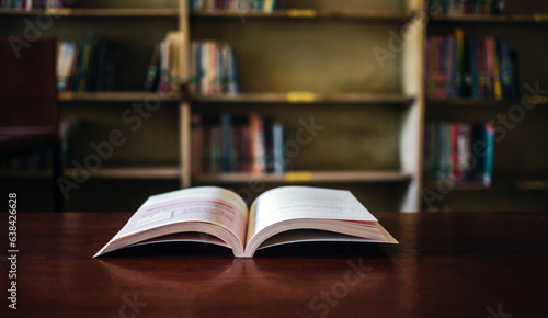 On a wooden table, there's an open book with a library visible in the background. A stack of books nearby adds to the theme of educational learning.