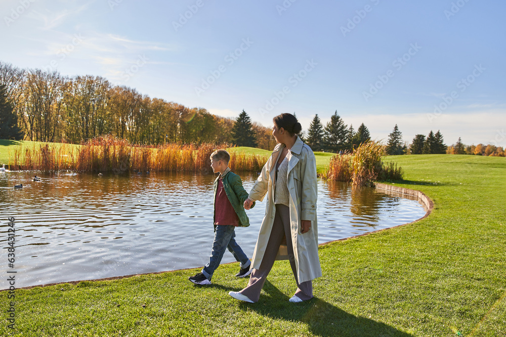 family bonding, african american mother walking with son along pond, hold hands, autumn, nature family bonding, african american mother walking with son along pond, hold hands, autumn, nature