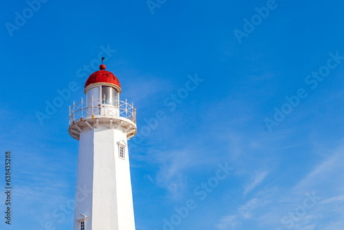 a landscape with a blue sky and a lighthouse