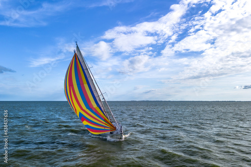 Quadro su tela Drone shot of the bow of a sailboat healed over with a bright colourful genoa, g