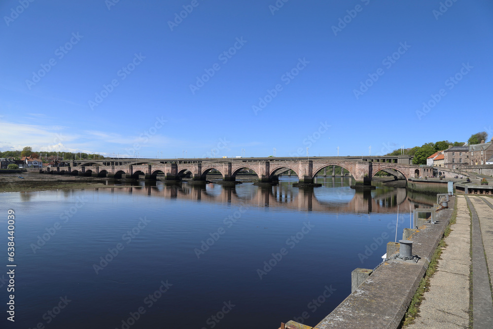 A view upstream along the River Tweed towards the ancient bridge at Berwick-upon-Tweed in Northumberland, England, UK.