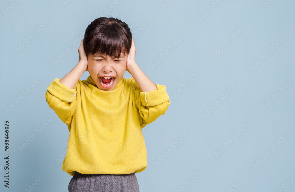A little girl is covering her ears with her hands. A little girl is covering her ears with her hands.