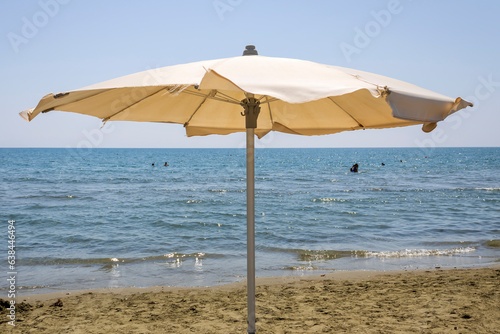 Parasol on sandy beach in front of blue sea and sky, Cyprus © Olga