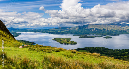 Hikers descending Conic Hill towards Loch Lomond with beautiful mountain scenery
