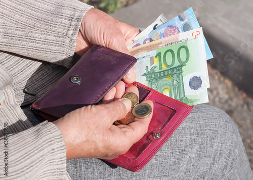 Obraz na plátně Euro banknotes and coins in the hands of an elderly woman.